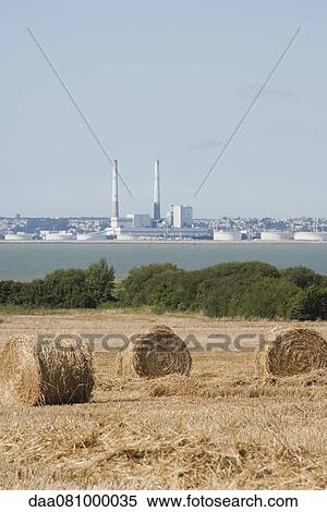 Field with bales of hay in foreground, power station in background View Large Photo Image Stock Photography - Field with bales of hay in foreground, power station in background. Fotosearch