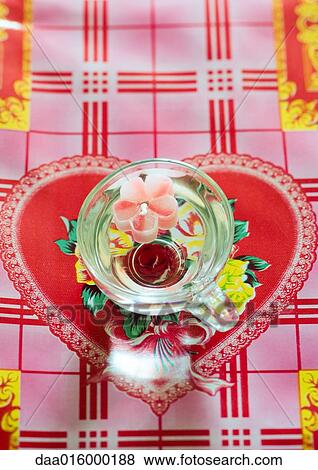 Stock Photo - Flower-shaped candle floating in cup. Fotosearch