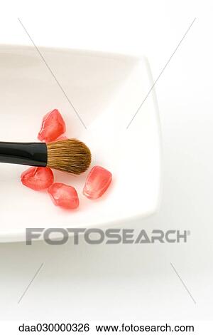 Stock Photograph - Fresh pomegranate seeds and make-up brush. Fotosearch