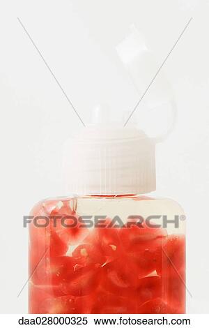 Stock Photography - Fresh pomegranate seeds in cosmetic bottle. Fotosearch