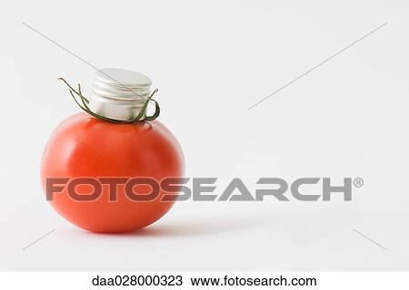 Stock Image - Fresh vine tomato with bottle cap on top of it. Fotosearch