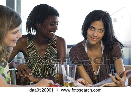 Stock Photo - Friends hanging out together in cafe. Fotosearch