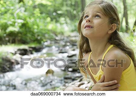 Girl beside stream, looking up in awe View Large Photo Image Picture - Girl beside stream, looking up in awe. Fotosearch