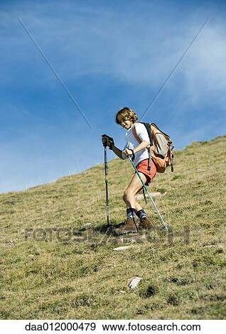 Stock Photo - Girl hiking down mountain. Fotosearch
