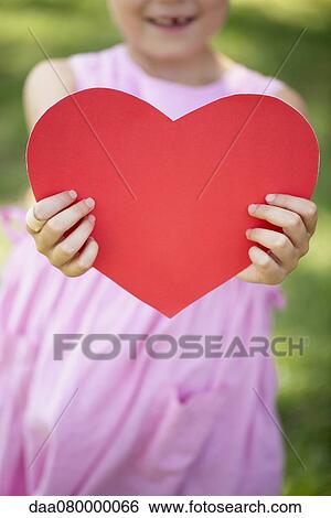 Girl holding paper heart, cropped View Large Photo Image Stock Photograph - Girl holding paper heart, cropped. Fotosearch