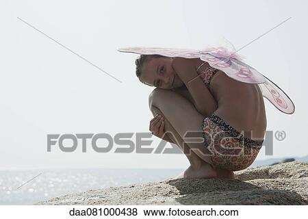 Girl in bikini wearing butterfly costume, crouching on rock View Large Photo Image Stock Photo - Girl in bikini wearing butterfly costume, crouching on rock. Fotosearch
