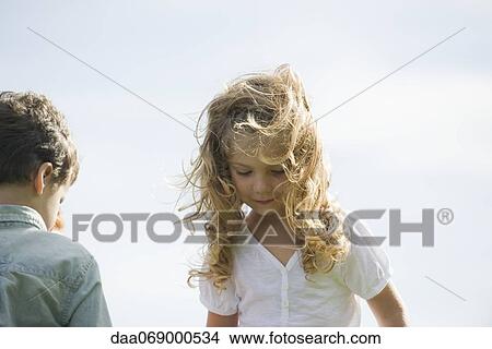 Girl outdoors on windy day, looking down in thought View Large Photo Image Picture - Girl outdoors on windy day, looking down in thought. Fotosearch