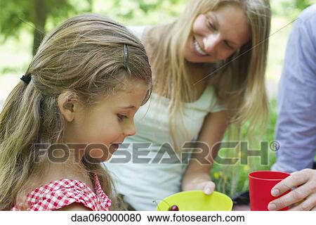 Girl relaxing with her parents outdoors View Large Photo Image Stock Image - Girl relaxing with her parents outdoors. Fotosearch