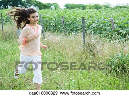 Girl running in field View Large Photo Image Stock Photo - Girl running in field. Fotosearch