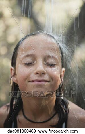Girl under running water outdoors View Large Photo Image Stock Photo - Girl under running water outdoors. Fotosearch