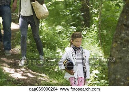 Girl walking in woods with parents View Large Photo Image Picture - Girl walking in woods with parents. Fotosearch