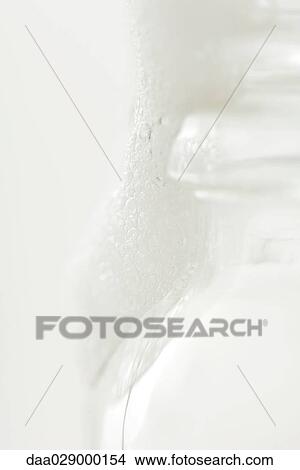 Glass bottle and soap suds, close-up View Large Photo Image Picture - Glass bottle and soap suds, close-up. Fotosearch
