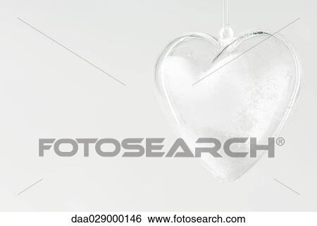 Glass heart ornament filled with snow, close-up View Large Photo Image Stock Photograph - Glass heart ornament filled with snow, close-up. Fotosearch