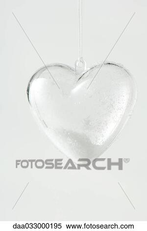 Glass heart ornament filled with snow, close-up View Large Photo Image Stock Photography - Glass heart ornament filled with snow, close-up. Fotosearch
