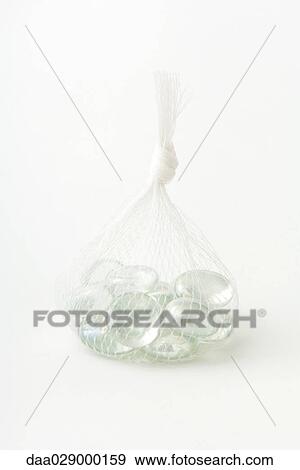 Glass pebbles in mesh bag, close-up View Large Photo Image Stock Photo - Glass pebbles in mesh bag, close-up. Fotosearch