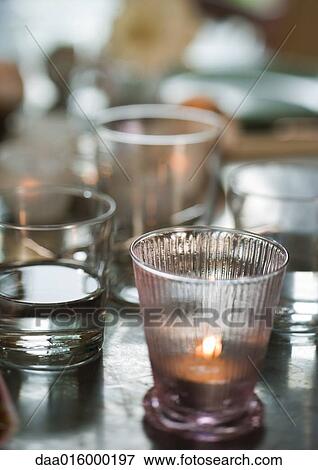 Stock Photo - Glasses and candles on table. Fotosearch