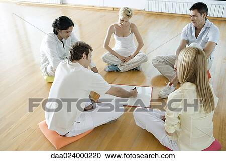 Group of adults sitting on cushions on floor, one man drawing on drywipe board View Large Photo Image Stock Image - Group of adults sitting on cushions on floor, one man drawing on drywipe board. Fotosearch