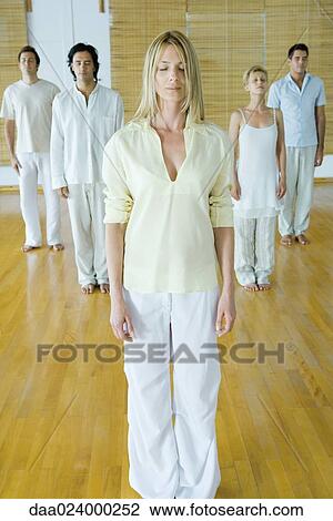 Stock Image - Group of adults standing, meditating. Fotosearch