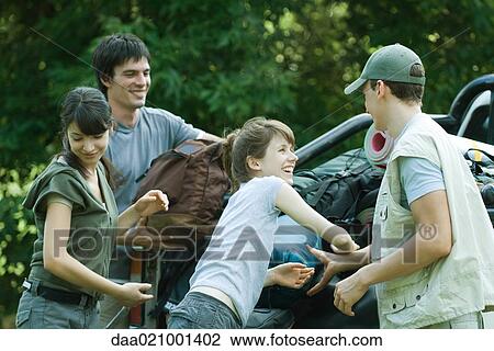Stock Image - Group of hikers loading back of pick-up truck. Fotosearch