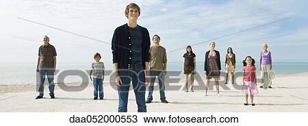 Group of individuals standing on beach, smiling optimistically View Large Photo Image Stock Image - Group of individuals standing on beach, smiling optimistically. Fotosearch
