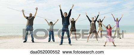 Group of people on beach with arms raised enjoying fresh sea air View Large Photo Image Stock Image - Group of people on beach with arms raised enjoying fresh sea air. Fotosearch