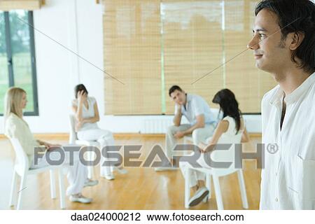 Group therapy session, man standing in foreground, smiling View Large Photo Image Stock Image - Group therapy session, man standing in foreground, smiling. Fotosearch