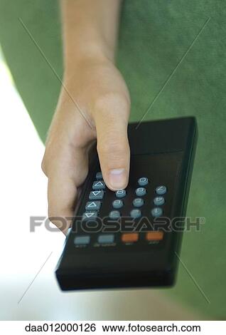 Stock Photograph - Hand pressing button on remote control. Fotosearch