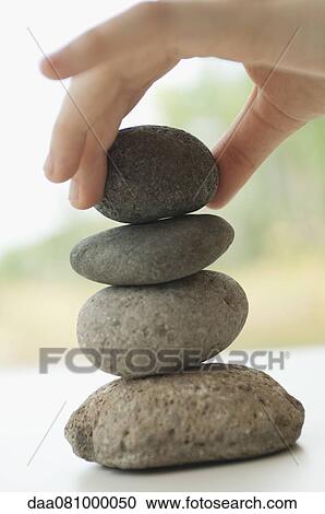 Hand stacking pebbles View Large Photo Image Stock Image - Hand stacking pebbles. Fotosearch