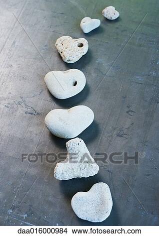 Heart-shaped stones arranged in curved line View Large Photo Image Picture - Heart-shaped stones arranged in curved line. Fotosearch