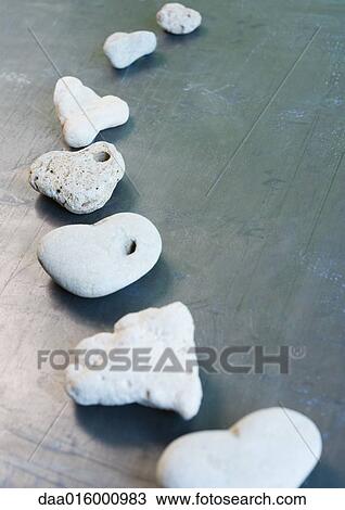 Heart-shaped stones arranged in curved line View Large Photo Image Stock Image - Heart-shaped stones arranged in curved line. Fotosearch