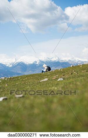 Hiker sitting in mountain landscape View Large Photo Image Stock Image - Hiker sitting in mountain landscape. Fotosearch