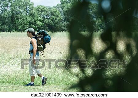 Stock Photo - Hiker walking through field. Fotosearch