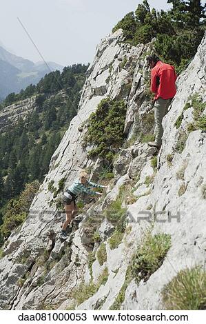 Stock Image - Hikers climbing on rock. Fotosearch