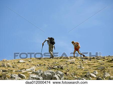 Picture - Hikers on mountainous landscape. Fotosearch