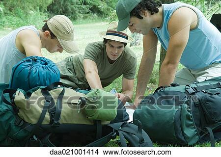 Hikers sitting on ground, looking at map View Large Photo Image Picture - Hikers sitting on ground, looking at map. Fotosearch
