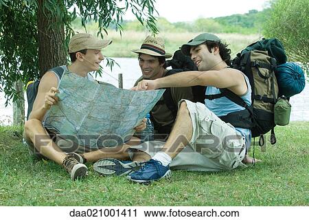 Hikers sitting on ground, looking at map View Large Photo Image Stock Image - Hikers sitting on ground, looking at map. Fotosearch
