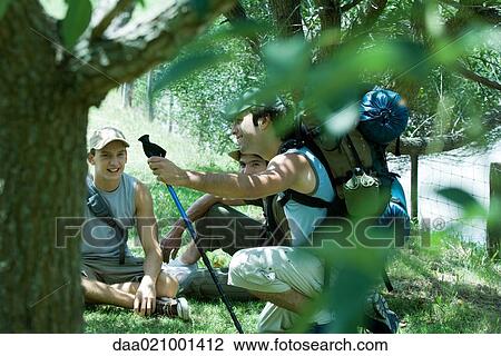 Hikers sitting on ground, looking at map View Large Photo Image Stock Image - Hikers sitting on ground, looking at map. Fotosearch