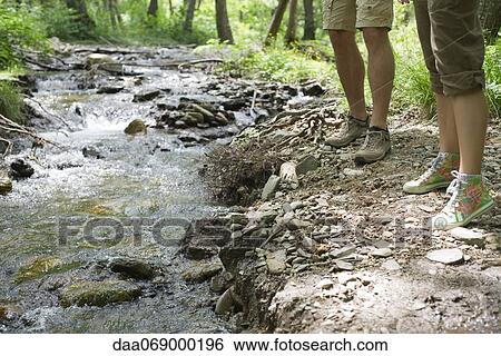 Hikers standing beside stream, cropped View Large Photo Image Stock Photograph - Hikers standing beside stream, cropped. Fotosearch