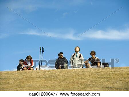 Stock Photo - Hikers taking break, one with eyes closed and head back. Fotosearch