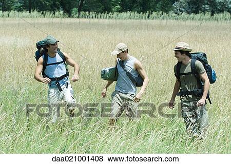 Stock Photo - Hikers walking through field. Fotosearch