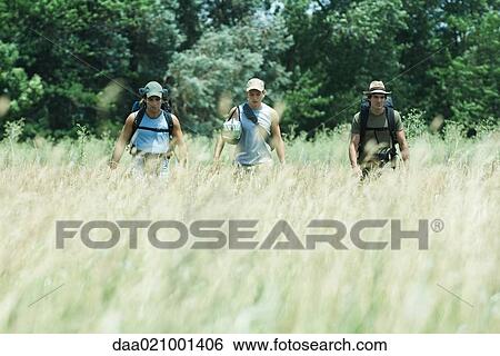 Stock Photograph - Hikers walking through field. Fotosearch