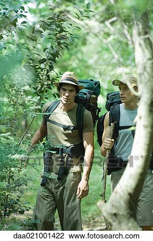 Stock Image - Hikers walking through woods. Fotosearch