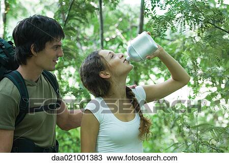 Hiking couple, woman drinking water View Large Photo Image Stock Image - Hiking couple, woman drinking water. Fotosearch