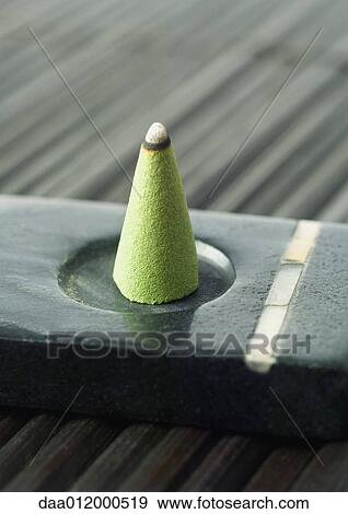 Stock Photo - Incense cone burning in incense holder. Fotosearch