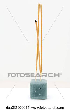 Picture - Incense sticking up out of incense holder. Fotosearch