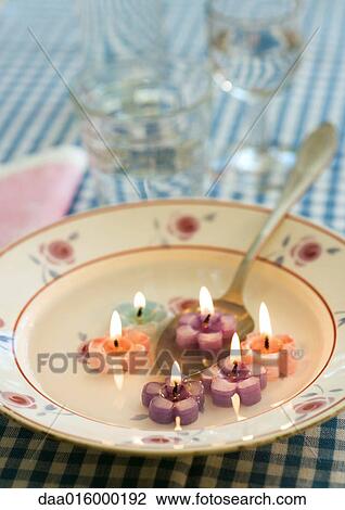 Lit flower-shaped candles in soup plate, with spoon View Large Photo Image Stock Image - Lit flower-shaped candles in soup plate, with spoon. Fotosearch