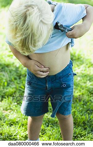 Little boy lifting shirt up and looking down at naval View Large Photo Image Stock Photograph - Little boy lifting shirt up and looking down at naval. Fotosearch