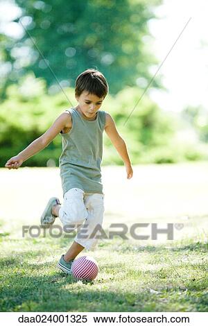 Little boy outdoors, kicking ball View Large Photo Image Stock Photography - Little boy outdoors, kicking ball. Fotosearch