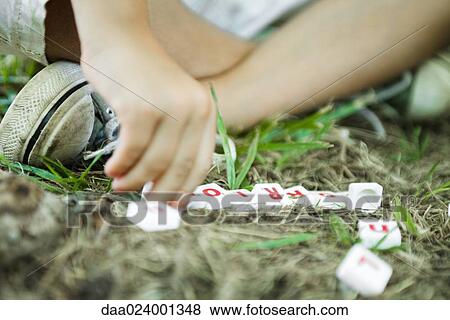 Little boy outdoors, using letter tiles to spell words, cropped View Large Photo Image Stock Photo - Little boy outdoors, using letter tiles to spell words, cropped. Fotosearch