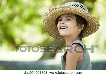Stock Photo - Little boy outdoors, wearing straw hat, smiling. Fotosearch